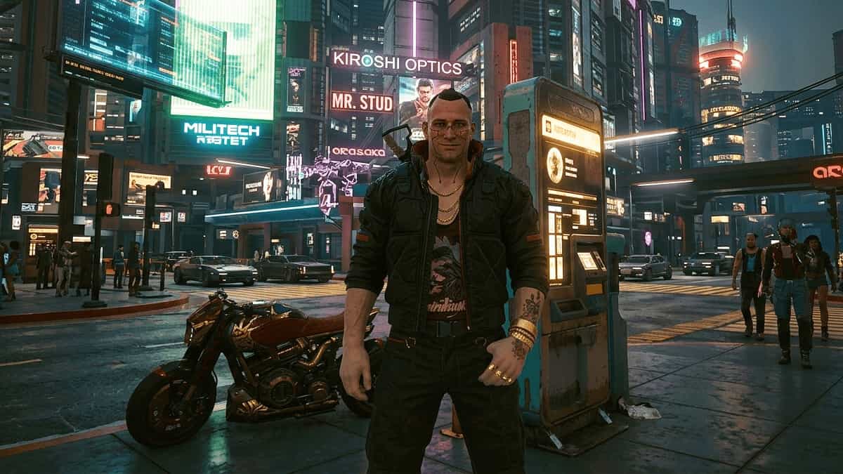 Jackie Welles standing in a neon-lit Night City street with a mohawk, gold chains, and his motorcycle parked nearby.